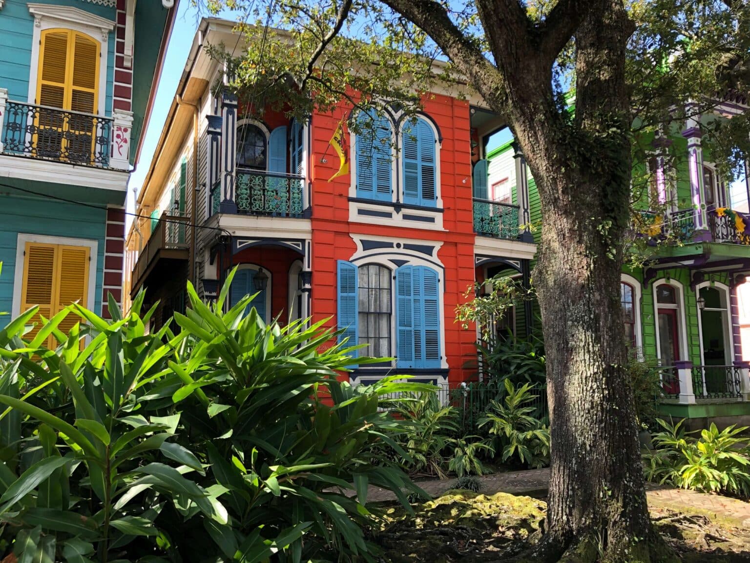 Colorful multi-story house surrounded by lush greenery.