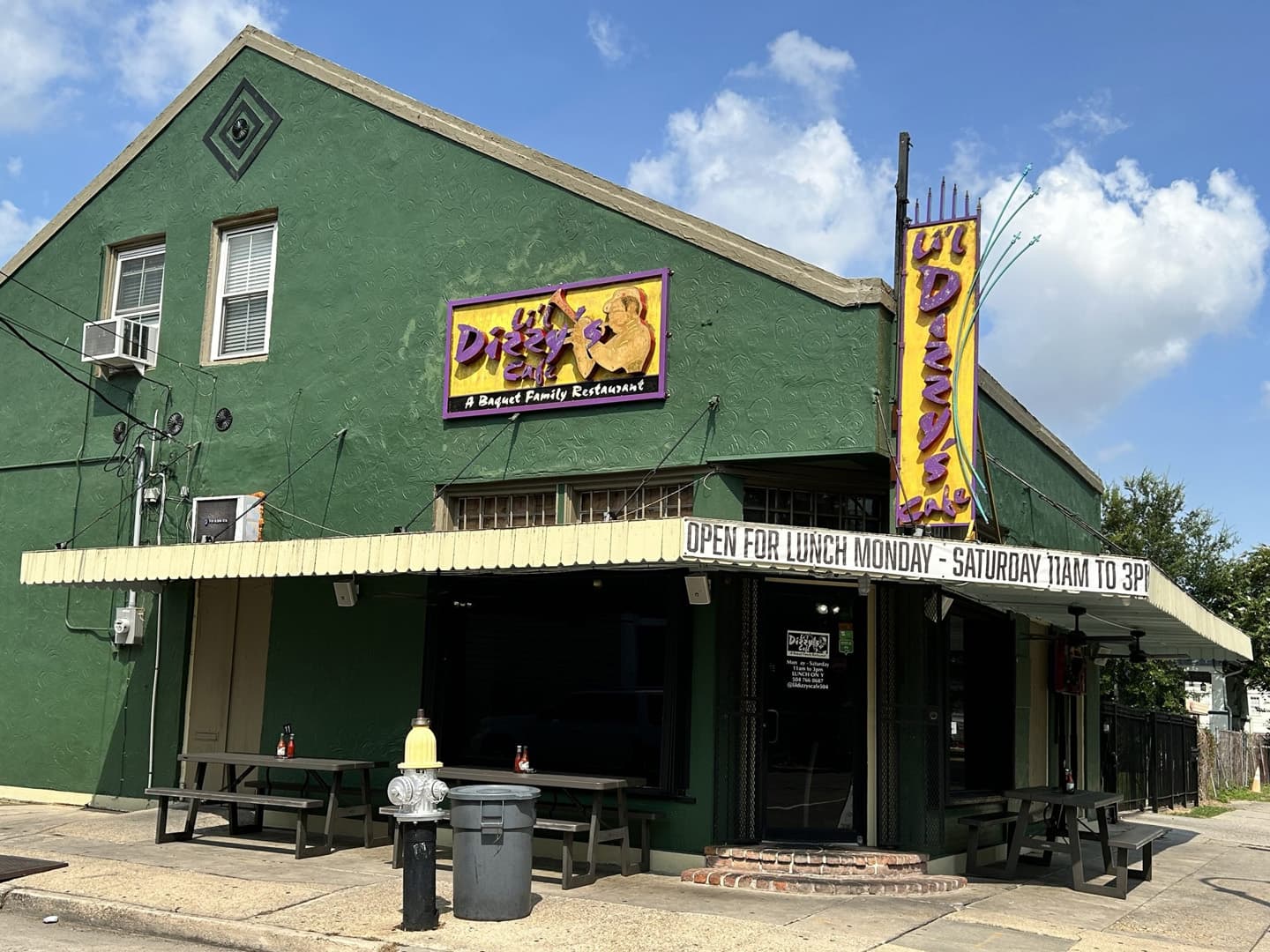 A green family restaurant with a sign that reads "Dizzy's" and outdoor seating.
