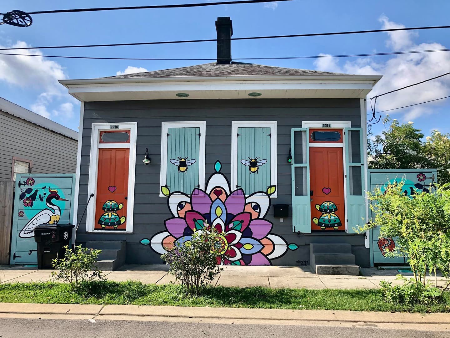 Colorful mural-adorned house featuring vibrant doors and decorative elements.
