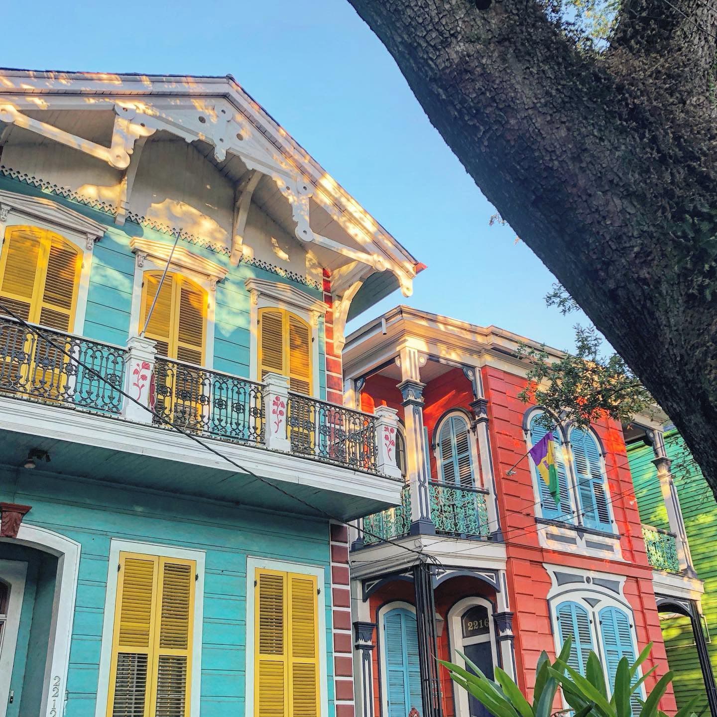 Colorful Victorian-style houses with balconies under a clear blue sky.