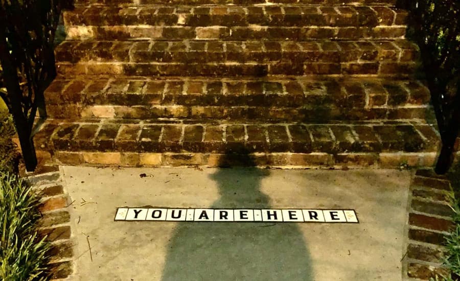 A "YOU ARE HERE" sign is displayed on the ground near a brick staircase.