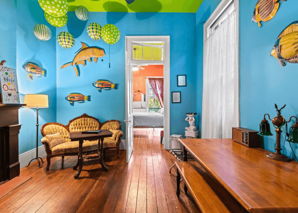 A brightly colored living space features fish decorations, hanging lanterns, and vintage furniture.
