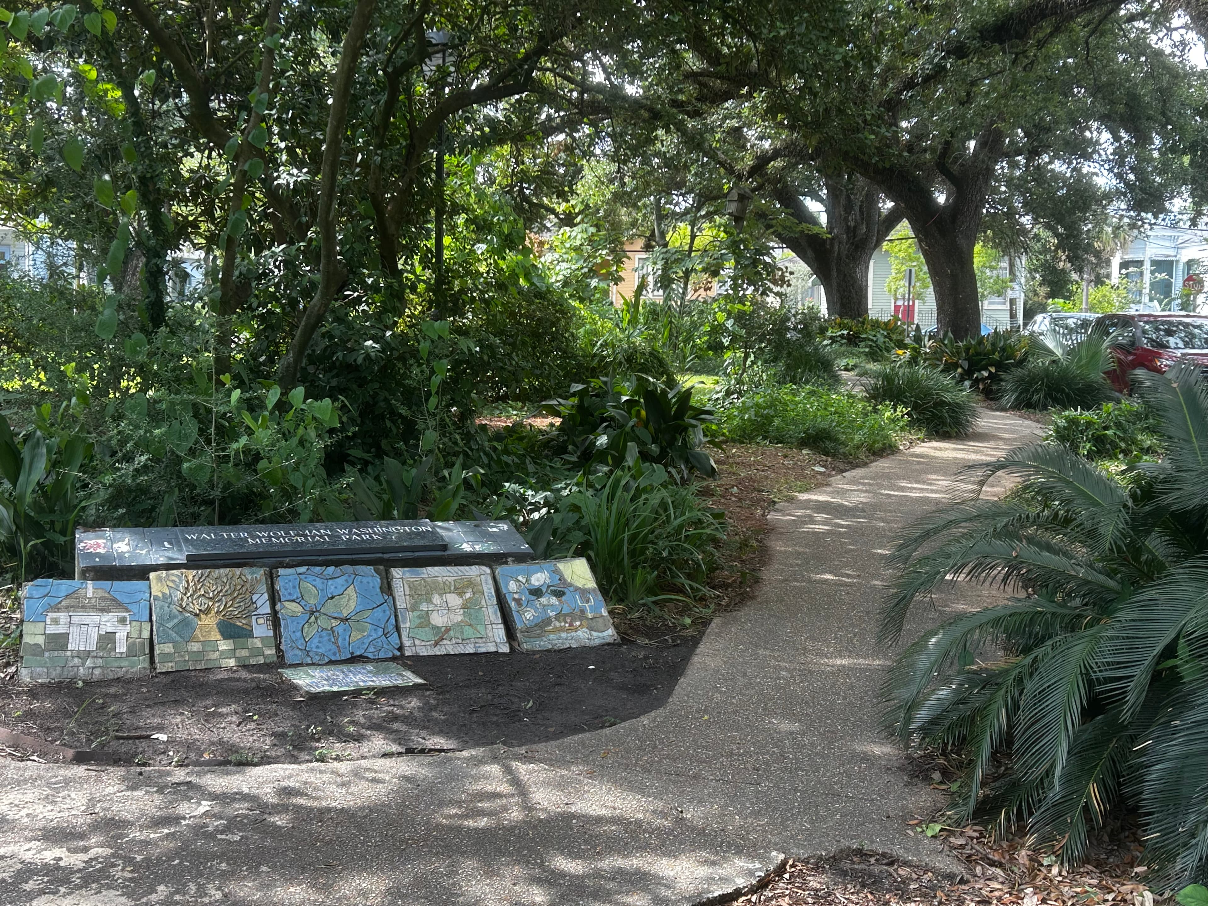 A meandering pathway through a lush garden featuring a mosaic display.