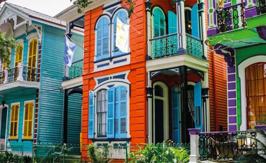 Vibrant, colorful houses with ornate details line a street, showcasing a mix of bold colors and unique architecture.