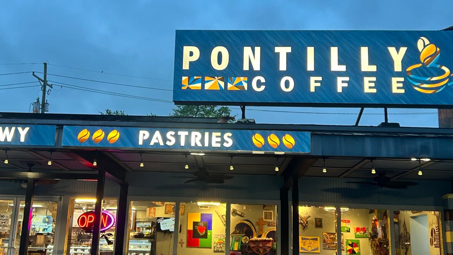 A cozy coffee shop sign that reads "PONTILLY COFFEE" with illuminated text for pastries and an open sign. A cozy coffee shop sign that reads "PONTILLY COFFEE" with illuminated text for pastries and an open sign.